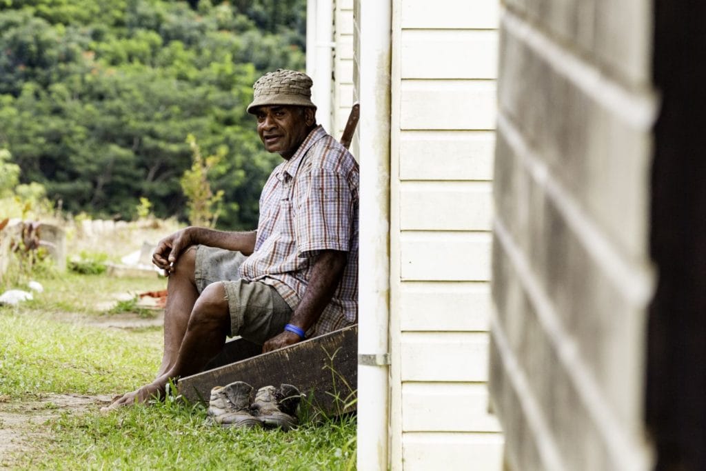 A man sitting infront of a building