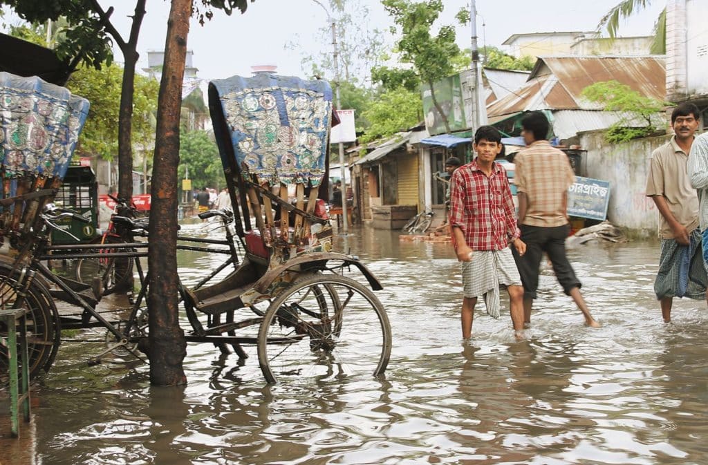 A man is walking through floodwater