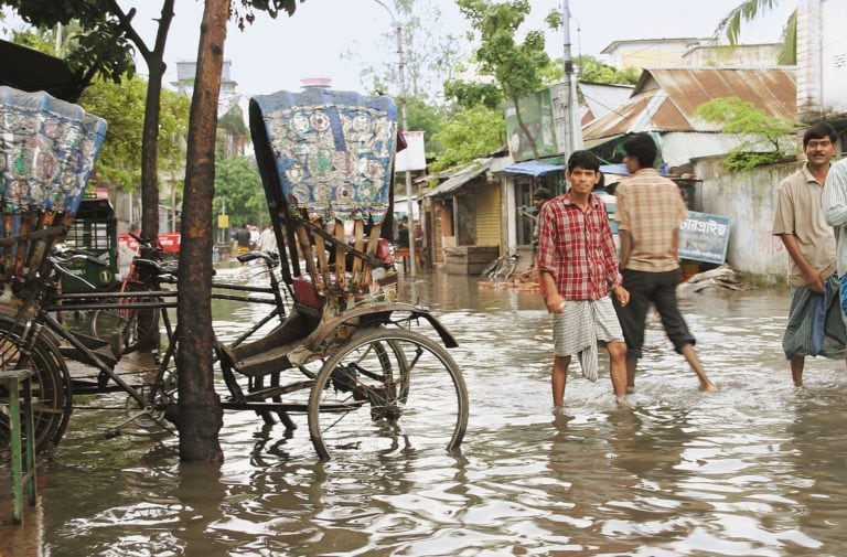 A man is walking through floodwater