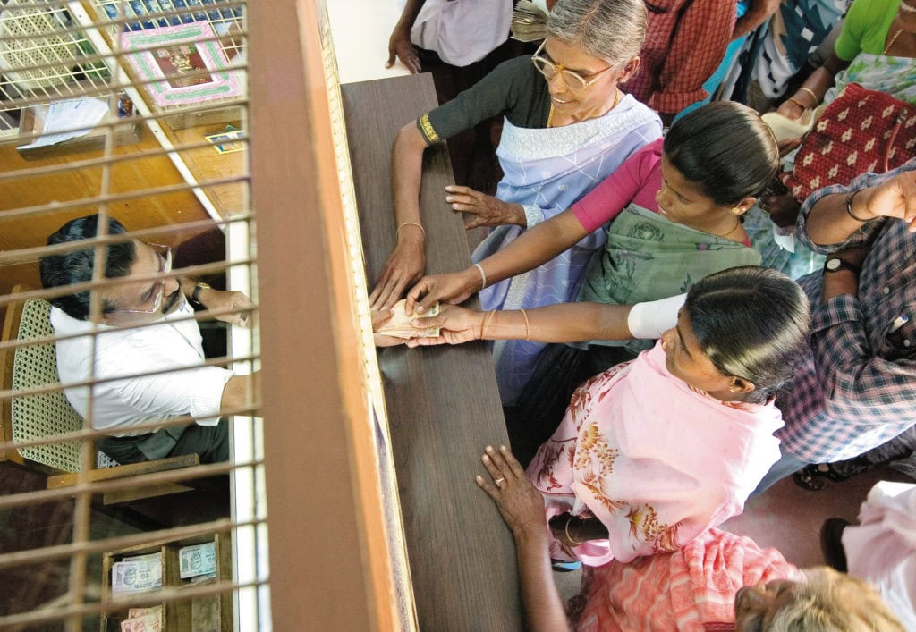 Money is handed over to women at the bank.