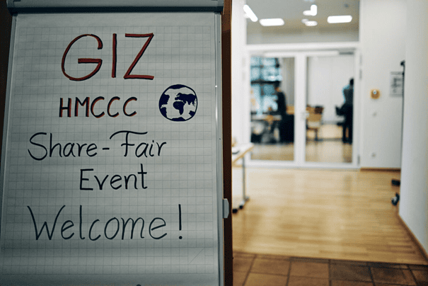 The Share-Fair event welcome sign and, next to it, the hallway leading to the event.